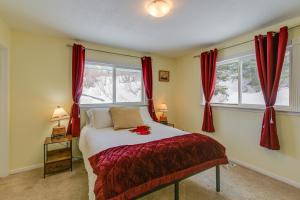 1 Schlafzimmer mit einem Bett und 2 Fenster mit roten Vorhängen in der Unterkunft Cozy Anchorage Vacation Rental with Deck, Gas Grill in Anchorage