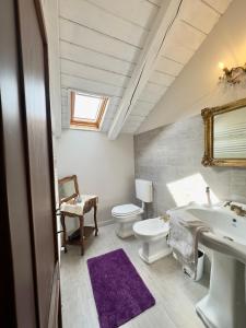 a bathroom with a white toilet and a sink at Quart de Lune - Boutique B&B in Aosta