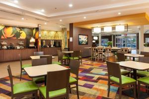 a restaurant with tables and chairs and a bar at Fairfield Inn & Suites by Marriott Vernon in Vernon
