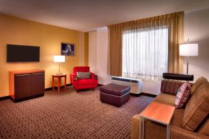 a hotel room with a couch and chairs and a tv at TownePlace Suites by Marriott Salt Lake City-West Valley in West Valley City