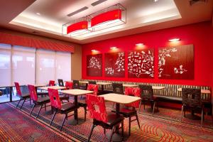 a restaurant with tables and chairs and red walls at TownePlace Suites by Marriott Salt Lake City-West Valley in West Valley City