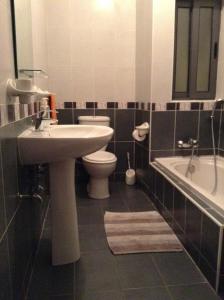 La salle de bains est pourvue d'un lavabo, de toilettes et d'une baignoire. dans l'établissement Merhba Apartment, à San Pawl il-Baħar