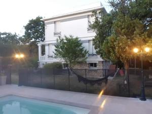 a house in the background with a fence and a swimming pool at Logement à 30min de la défense avec piscine privative in Conflans-Sainte-Honorine