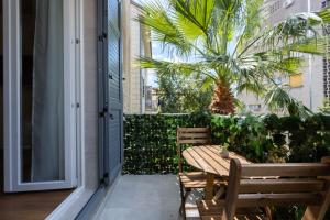 un patio con una mesa de madera, sillas y una palmera en Luxury Rooms Fetivi en Split