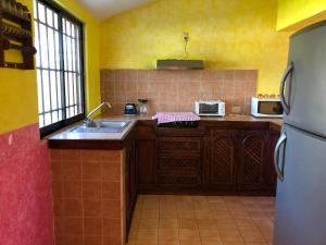 a kitchen with a sink and a refrigerator at Hermosa Casa Ikal en Acapulco in Barra de Coyuca