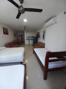 a room with two beds and a ceiling fan at Apt Edificio los Delfines Playa in Cartagena de Indias