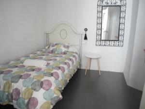 ベヘール・デ・ラ・フロンテーラにあるCasa Lauraのベッドルーム1室(鏡付きベッド1台、テーブル付)