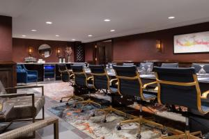 a waiting room with a long table and chairs at Seven Gables Inn, St Louis West, a Tribute Portfolio Hotel in Saint Louis