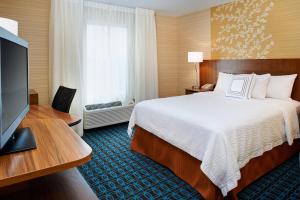 a hotel room with a bed and a flat screen tv at Fairfield Inn by Marriott Port Huron in Port Huron