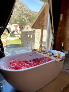 a bath tub filled with red peppers in a window at Bujtina Miqesia in Theth