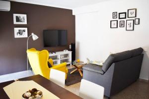 ein Wohnzimmer mit einem Sofa und einem TV in der Unterkunft Departamento céntrico para disfrutar en familia in Sagunt