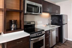 Towneplace Suites By Marriott Louisville Northeast في لويزفيل: مطبخ مع موقد وميكروويف