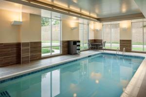 a swimming pool in a hotel room with windows at Towneplace Suites By Marriott Louisville Northeast in Louisville