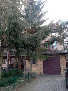 a house with a garage and a tree in front of it at Meier House Wawer in Warsaw