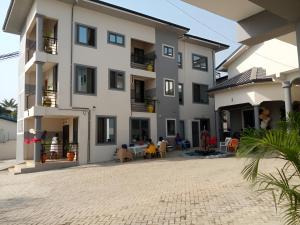 een appartementencomplex met een binnenplaats ervoor bij Queen's Hill Lodge in Oblogo