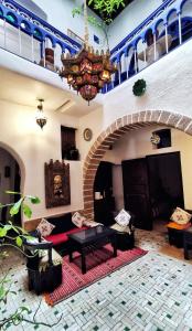 salon z kanapą i żyrandolem w obiekcie Hotel Dar El Qdima w mieście As-Suwajra