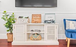 a white console table in a living room with a blue chair at Private Rooftop & Parking - 3 Blocks to King St in Charleston +41 photos