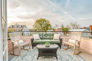 a patio with a couch and two chairs on a balcony at Rooftop Deck with Parking - 3 Blocks to KING in Charleston