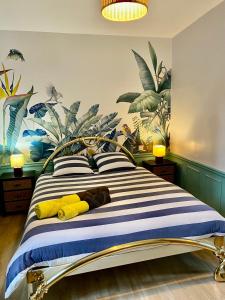 ein Schlafzimmer mit einem gestreiften Bett mit zwei gelben Handtüchern darauf in der Unterkunft Bel Appartement pour 2 personnes vue latérale sur le port in Le Tréport