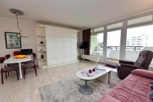 a living room with a couch and a table at Haus "Panorama" Appartement PAN069 in Duhnen