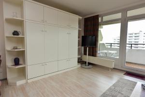 a living room with white cabinets and a window at Haus "Panorama" Appartement PAN069 in Duhnen +22 photos