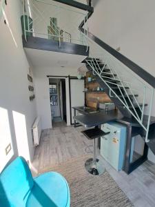 ein Wohnzimmer mit einer Treppe und einem blauen Stuhl in der Unterkunft Okeyloft Coyhaique 3 in Coihaique