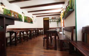 a row of wooden tables and benches in a restaurant at Montenegro Hostel B&B Kotor in Kotor