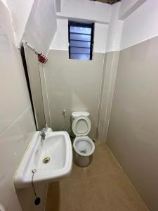 a small bathroom with a toilet and a sink at Lorenza 2 and 3 in Buruanga