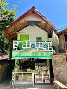 una pequeña tienda con un edificio verde y blanco en Lorenza 2 and 3, en Buruanga