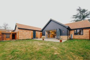 a home with a black house and a yard at Cottage in the Heart of Suffolk in Stowmarket