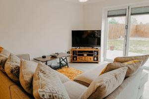 a living room with a couch and a tv at Cottage in the Heart of Suffolk in Stowmarket