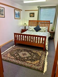 a bedroom with a wooden bed and a rug at Whitemore B&B 