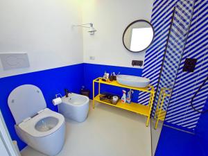 a blue and white bathroom with a toilet and a sink at La Pigolina in Positano