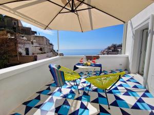 a balcony with a table and an umbrella at La Pigolina in Positano