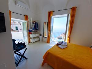 a bedroom with a bed and a large window at La Pigolina in Positano