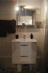 a bathroom with a white sink and a mirror at Chez BEN avec tout le confort clim wifi Netflix gratuit in Castres