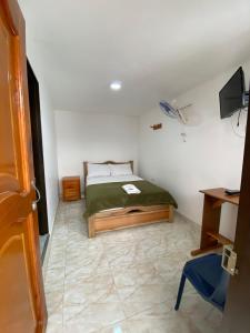 Habitación pequeña con cama y escritorio. en Hotel la Victoria, en San Roque