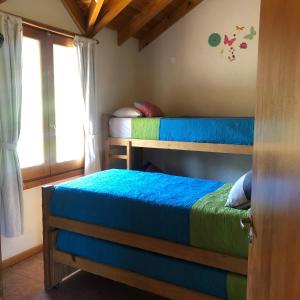 1 dormitorio con 2 literas y ventana en Cabañas Rincón en Villa Meliquina