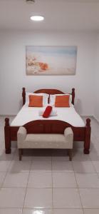 a bedroom with a large bed with orange pillows at Résidence KAYA, Marie-Galante in Grand-Bourg