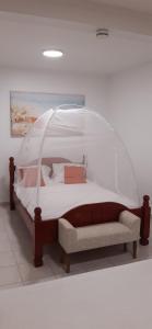 a bed with a canopy in a room at Résidence KAYA, Marie-Galante, Vue Mer in Grand-Bourg