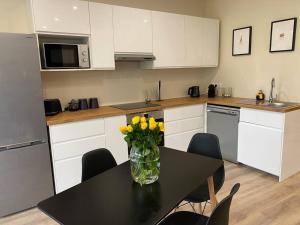 a kitchen with a table with a vase of flowers on it at Duplex By Aurelle 2-Wifi-10 mn centre Strasbourg- proche Parlement Européen in Schiltigheim