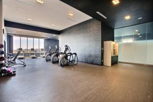 einen Fitnessraum mit Laufbändern und Heimtrainern in einem Zimmer in der Unterkunft Courtyard by Marriott Montreal Brossard in Brossard