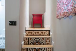 a red cabinet sitting on top of three stairs at Dimora del Cardinale - Residenza d'Epoca in Florence