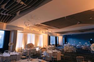 un salón de banquetes con mesas y sillas blancas en Courtyard by Marriott Montreal Brossard en Brossard