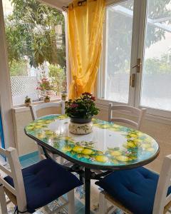 einen Glastisch in einem Zimmer mit Stühlen und einem Fenster in der Unterkunft La Casa del Limoneto in Favignana