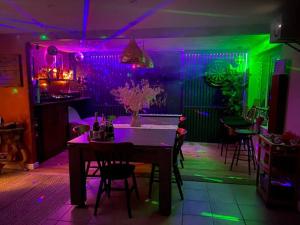 une salle à manger avec une table et des lumières violettes et vertes dans l'établissement Cheerful 3-bed detached home, à Nottingham