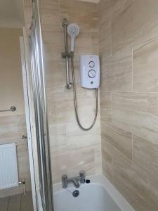 La salle de bains est pourvue d'une douche, d'une baignoire et d'un lavabo. dans l'établissement Cheerful 3-bed detached home, à Nottingham