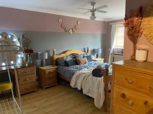 a bedroom with a bed and a dresser at Cheerful 3-bed detached home in Nottingham