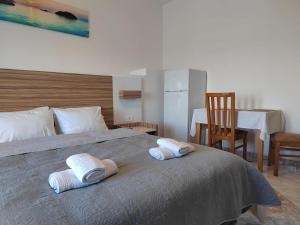 ein Schlafzimmer mit einem Bett mit zwei Handtüchern darauf in der Unterkunft Jacob's Sunrise cottage in Kissamos