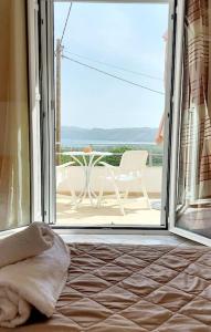 a bedroom with an open door with a view of a patio at Jacob's Sunrise cottage in Kissamos